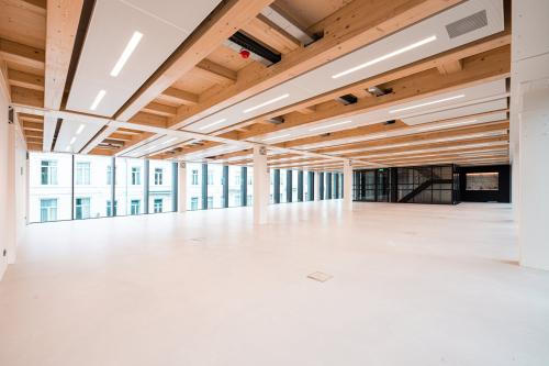 Spacious open floorplan office space with modern wooden ceiling beams and large windows in Pieter Cornelisz. Hooftstraat, Amsterdam Center, ideal for office space rental.