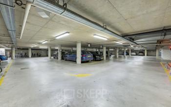 Spacious parking area with concrete ceiling and several parked cars, located at Stadhouderskade 55 in Amsterdam Center.