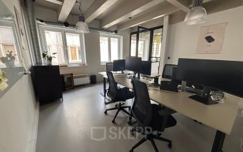 Bright office space at Kloveniersburgwal 131K, Amsterdam Center, featuring modern desks and chairs with computers, ideal for an office space rental.