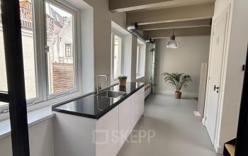 Bright and modern office space at Kloveniersburgwal 131K in Amsterdam Center featuring an indoor area with large windows and a minimalist design, ideal for your office space rental needs.