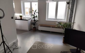 Bright office space at Kloveniersburgwal 131K in Amsterdam Center, featuring a modern setup with a desk, plants, and ample natural light, ideal for office space rental.