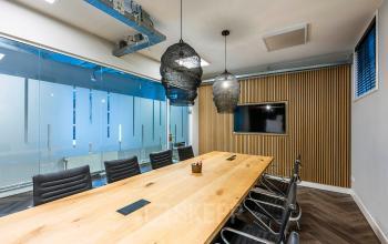 Contemporary office with wooden table and ergonomic chairs, ideal for office space rental at Rapenburgerstraat 173, Amsterdam Center.