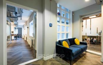 Modern office space at Rapenburgerstraat 173 in Amsterdam Center, featuring a cozy lounge area and workspace setup for rent.