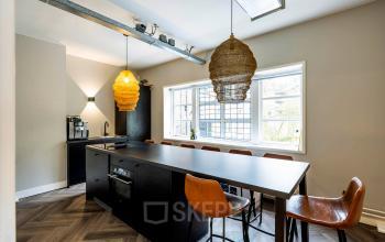 Modern office kitchen area with a central island and seating at Rapenburgerstraat 173, ideal for rent office space in Amsterdam Center.
