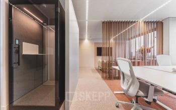 Modern office space for rent at Piet Heinkade 55 in Amsterdam Center featuring a sleek meeting area and a private phone booth.