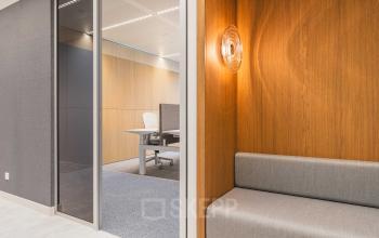 Modern office space with sleek wooden paneling and a comfortable seating area at Piet Heinkade 55, Amsterdam Center. Ideal for those looking for office space rental.