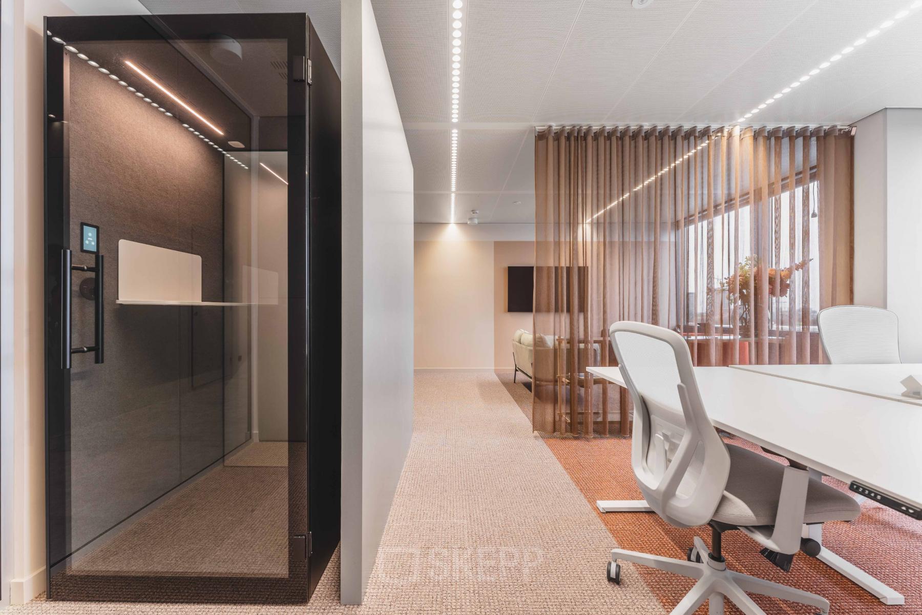 Modern office space for rent at Piet Heinkade 55 in Amsterdam Center featuring a sleek meeting area and a private phone booth.