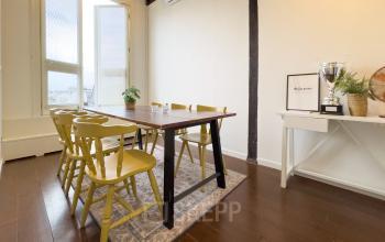 Bright conference room available for office space rental at Warmoesstraat 149-151, Amsterdam Center, featuring a large table, chairs, and decorative elements, perfect for meetings and collaborative work.