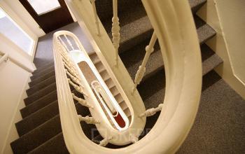Elegant spiral staircase inside the Warmoesstraat 149 - 151 office space rental in Amsterdam Center, showcasing architectural charm.