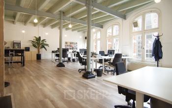 Spacious office space rental at Warmoesstraat 149-151 in Amsterdam Center with modern furniture and large windows.