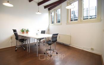 Modern office space rental at Warmoesstraat 149 - 151, Amsterdam Center, with a clean white table, chairs, and ample natural light.