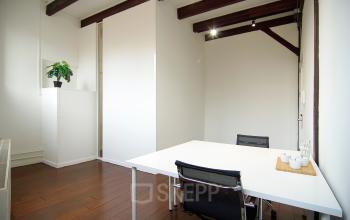 Modern office space rental at Warmoesstraat 149 - 151 in Amsterdam Center with a stylish desk, chair, and plant decor.