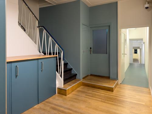 Interior view of Warmoesstraat 155, Amsterdam Center, showcasing a well-kept staircase and hallway with wooden floors, ideal for office space rental.
