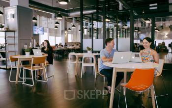 Professionals engaging in business discussions in a well-lit office space rental at Weteringschans 165, Amsterdam Center.