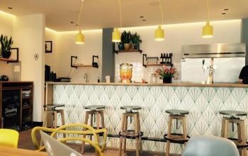 Cozy cafe-style kitchenette in office space rental at Weteringschans 165, Amsterdam Center, with modern bar stools and pendant lighting.