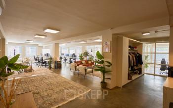 Bright and inviting office space with plants, desks, and a lounge area, ideal for rent in Amsterdam Center.
