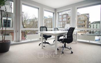 Bright office space at Kleine Gartmanplantsoen 21 in Amsterdam Center, featuring two desks and chairs, available for rent.
