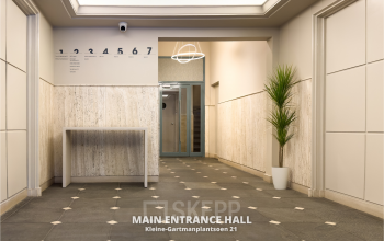 Entrance hall of an office at Kleine Gartmanplantsoen 21, Amsterdam Center, available for office space rental. Features tiled flooring and a modern light fixture.
