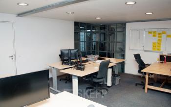 Interior office space at Zuiderkerkhof 72 featuring multiple desks with computers, ideal for a collaborative work environment in Amsterdam Center. Perfect for office space rental seekers.