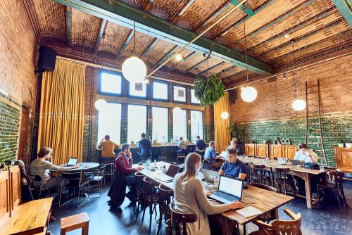 Cozy office space rental at Oudebrugsteeg 9, Amsterdam Center, with brick walls and large windows providing ample natural light.