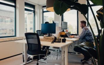 Modern office space at IJsbaanpad 2, Amsterdam De Schinkel, featuring desks and people engaging in business activities on computers. Ideal for anyone looking to rent office space in a vibrant location.