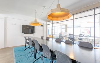 Conference room in the office located at Generaal Vetterstraat 77e, Amsterdam De Schinkel with a large table, chairs, and modern lighting.