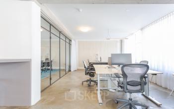Bright office space with modern furnishings at Generaal Vetterstraat 77e in Amsterdam De Schinkel. Glass-walled conference room, ergonomic chairs, and large windows for natural light.