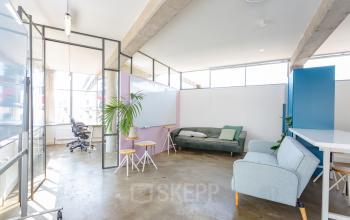 Bright and modern office space rental at Generaal Vetterstraat 77e, Amsterdam De Schinkel, featuring open workspaces with industrial design, glass partitions, and furnished with sofas and chairs.