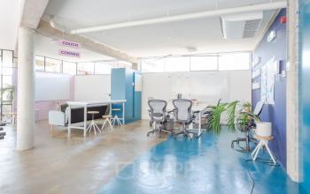 Modern office space at Generaal Vetterstraat 77e in Amsterdam De Schinkel, featuring open floorplan with desks, chairs, and a whiteboard.
