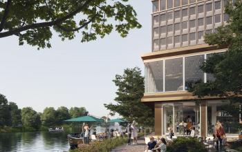 Exterior view of office building located at Rijnsburgstraat 9-11, Amsterdam De Schinkel, with people working and conversing outdoors near a canal.
