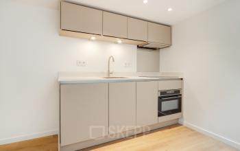 Modern office pantry with sleek cabinetry and under-cabinet lighting, ideal for office space rental at Schinkelkade 44, Amsterdam De Schinkel.