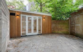 Exterior view of office to rent at Schinkelkade 44 in Amsterdam De Schinkel, featuring wooden facade and glass doors.