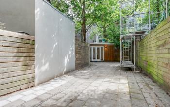 Outdoor space with paved flooring and surrounding wooden fences, part of an office to rent at Schinkelkade 44, Amsterdam De Schinkel.