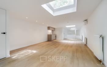 Bright office space rental at Schinkelkade 44, Amsterdam De Schinkel, with natural light from skylights and wooden floors, featuring minimal kitchen area.