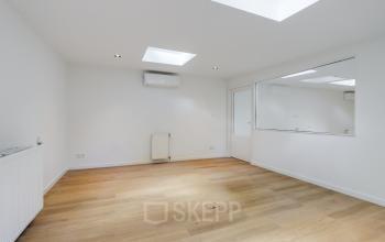 Bright office space for rent at Schinkelkade 44, Amsterdam De Schinkel, featuring wooden floors and a skylight.