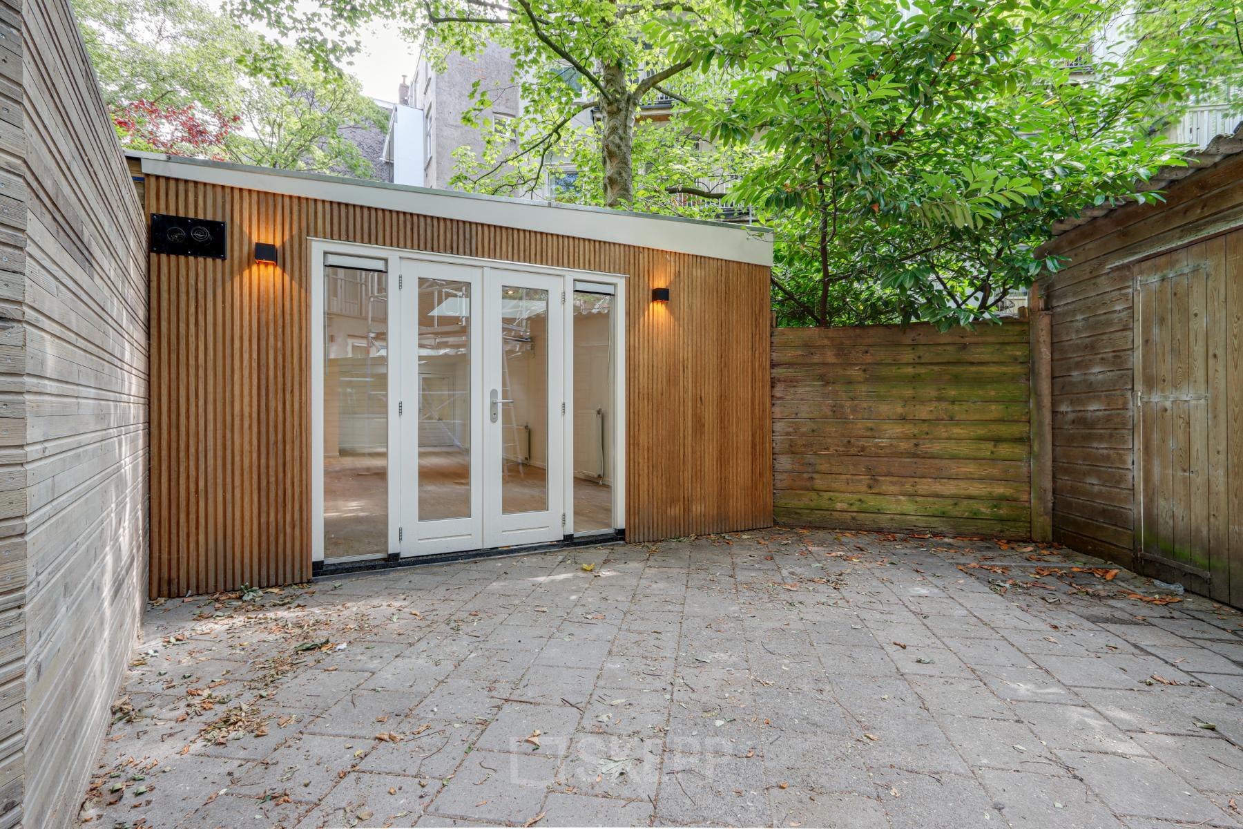 Exterior view of office to rent at Schinkelkade 44 in Amsterdam De Schinkel, featuring wooden facade and glass doors.