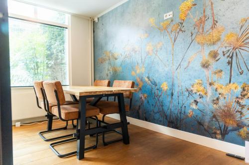 Office space to rent located at Keizersgracht 482, Amsterdam Canal Belt, featuring a modern wooden table with chairs and a colorful wall mural.