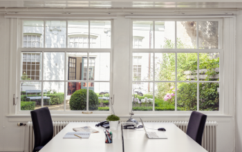Bright office space at Keizersgracht 62 – 64, Amsterdam Canal Belt, with desks and view of a garden, perfect for office space rental.