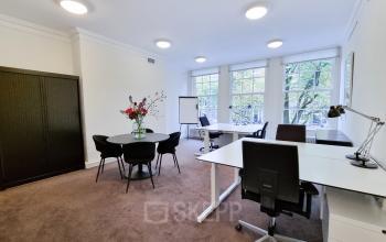Bright and spacious office space for rent at Keizersgracht 62 – 64 in Amsterdam Canal Belt, featuring desks, chairs, and a meeting table for a professional working environment.
