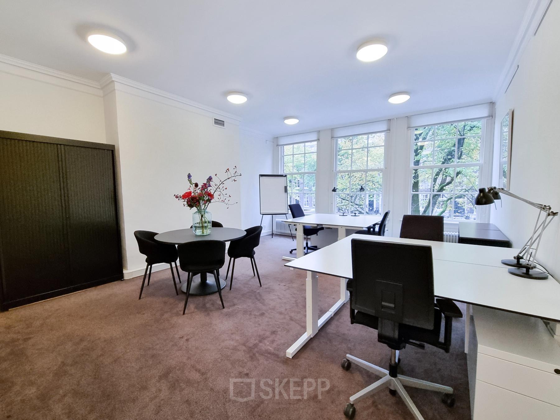 Elegantly furnished office space rental at Keizersgracht 62 – 64, Amsterdam Canal Belt, featuring desks, chairs, and a meeting area with natural light.