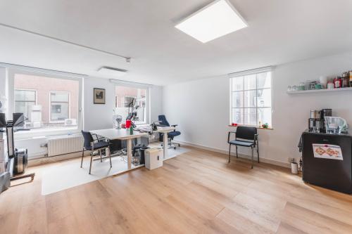 Furnished office space at Herengracht 221, Amsterdam Canal Belt with desks, chairs, and a coffee machine, ideal for office space rental.