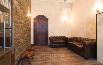 Elegant office space rental at Herengracht 282, showcasing classic leather sofas and warm, inviting ambiance in Amsterdam