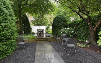 Tranquil garden area of Herengracht 282 office space rental in Amsterdam Canal Belt, with outdoor seating and lush greenery.