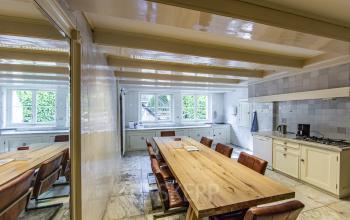 Stylish kitchen area at Herengracht 282 in Amsterdam Canal Belt, perfect for an office space rental with large windows and wooden tables.