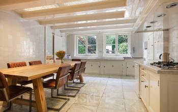 Spacious and bright office space rental at Herengracht 282, featuring a large meeting table, modern kitchen amenities, and an inviting atmosphere.