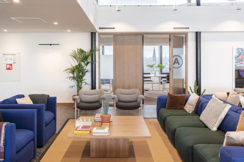 Stylish office lounge area at Stadhouderskade 5-6 in Amsterdam Canal Belt, featuring modern seating and a wooden coffee table. Ideal space for informal meetings or relaxing work breaks.