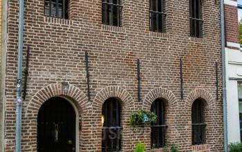 Exterior view of office building for rent at Vinkenstraat 79 HS, in Amsterdam Canal Belt, Amsterdam, showcasing the historic brick facade and arched windows.