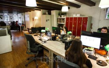 Office space rental at Vinkenstraat 79 HS, Amsterdam Canal Belt, featuring workstations with computers, wooden desks, and overhead lighting.