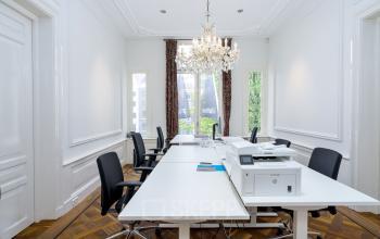Elegant office space rental in a classic building at Keizersgracht 452, Amsterdam Canal Belt, featuring high ceilings, wooden floors, modern desks, and a chandelier.