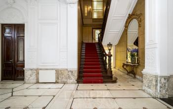 Interior view of office building at Keizersgracht 452, Amsterdam Canal Belt, with grand staircase, ornate decor, and marble flooring, highlighting office space rental in a prestigious location.